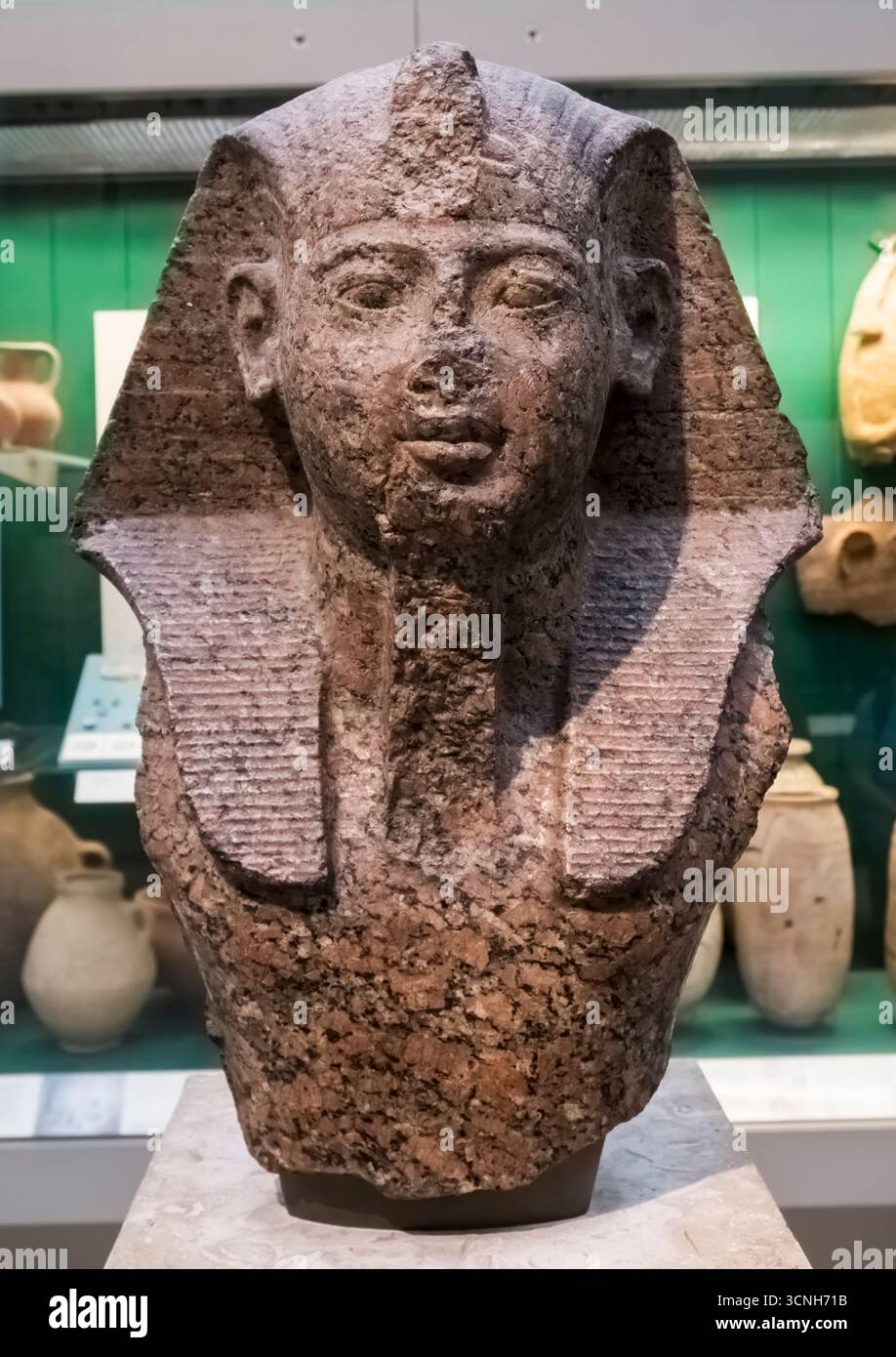 Rote Granitschnitzerei des Kopfes eines Pharaos der 19. Dynastie des Neuen Königreichs mit königlichem Kopfschmuck. Vielleicht Ramses II. C1250 v. Chr. Ausstellung im British Museum. Stockfoto
