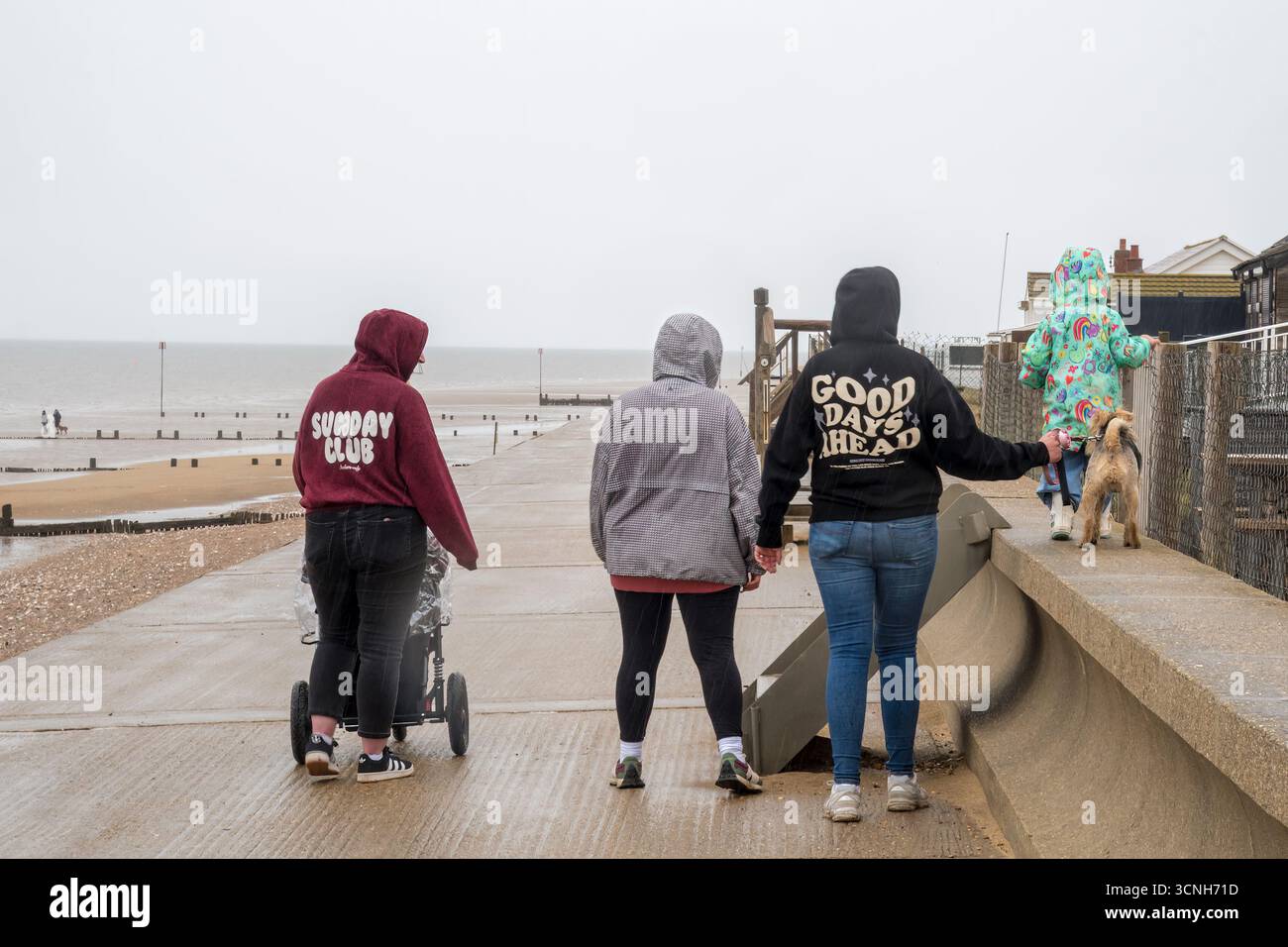 Leute, die im Regen auf der Hunstanton Promenade laufen. Stockfoto