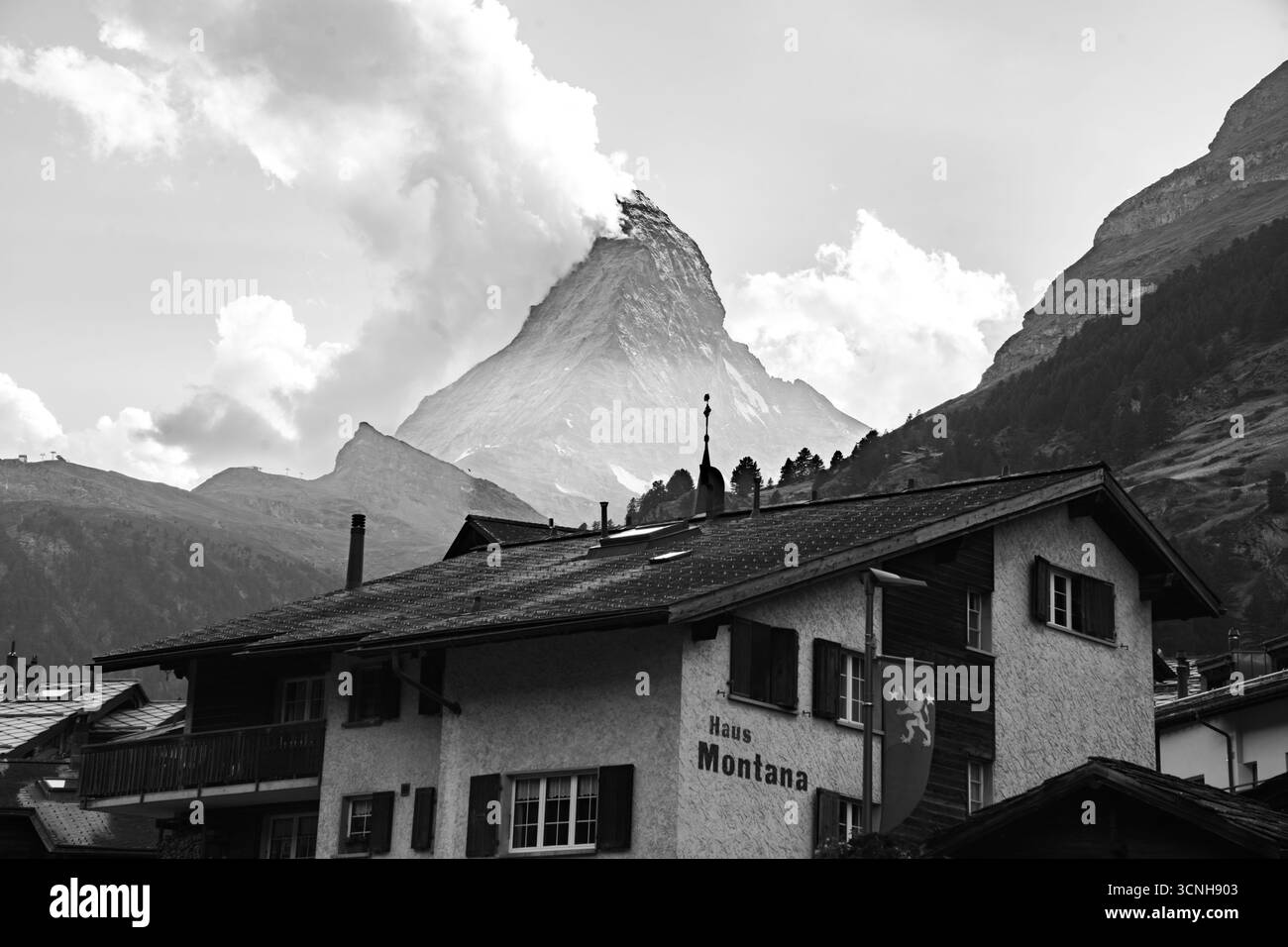 Stadt Zermatt mit dem Matterhorn im Hintergrund, Abendlichtern, Restaurants, Lodges, Geschäften und Touristen im Stadtzentrum Stockfoto