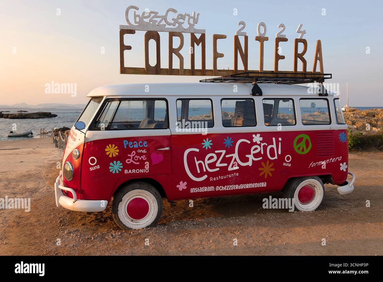 Formentera, Spanien - 23. September 2024: Ikonischer roter Volkswagen-Van von Chezz Gerdi in es Pujols, Balearen, Spanien, mit einem großen „Formentera 2024“ Stockfoto
