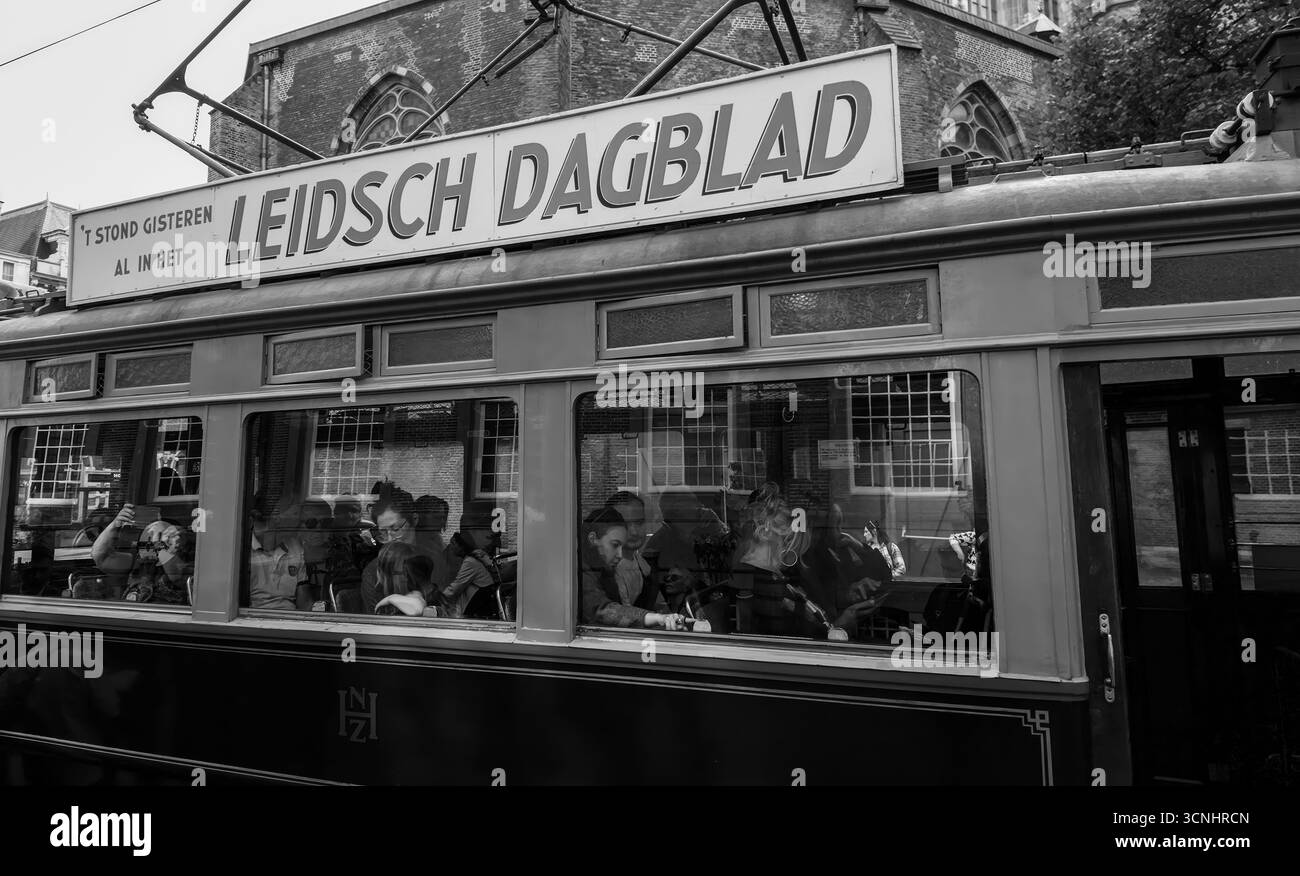 DEN HAAG, NIEDERLANDE - 14. SEPTEMBER 2025 - Oldtimer-Straßenbahn fährt durch das Stadtzentrum von Haag mit Passagieren im Inneren Stockfoto