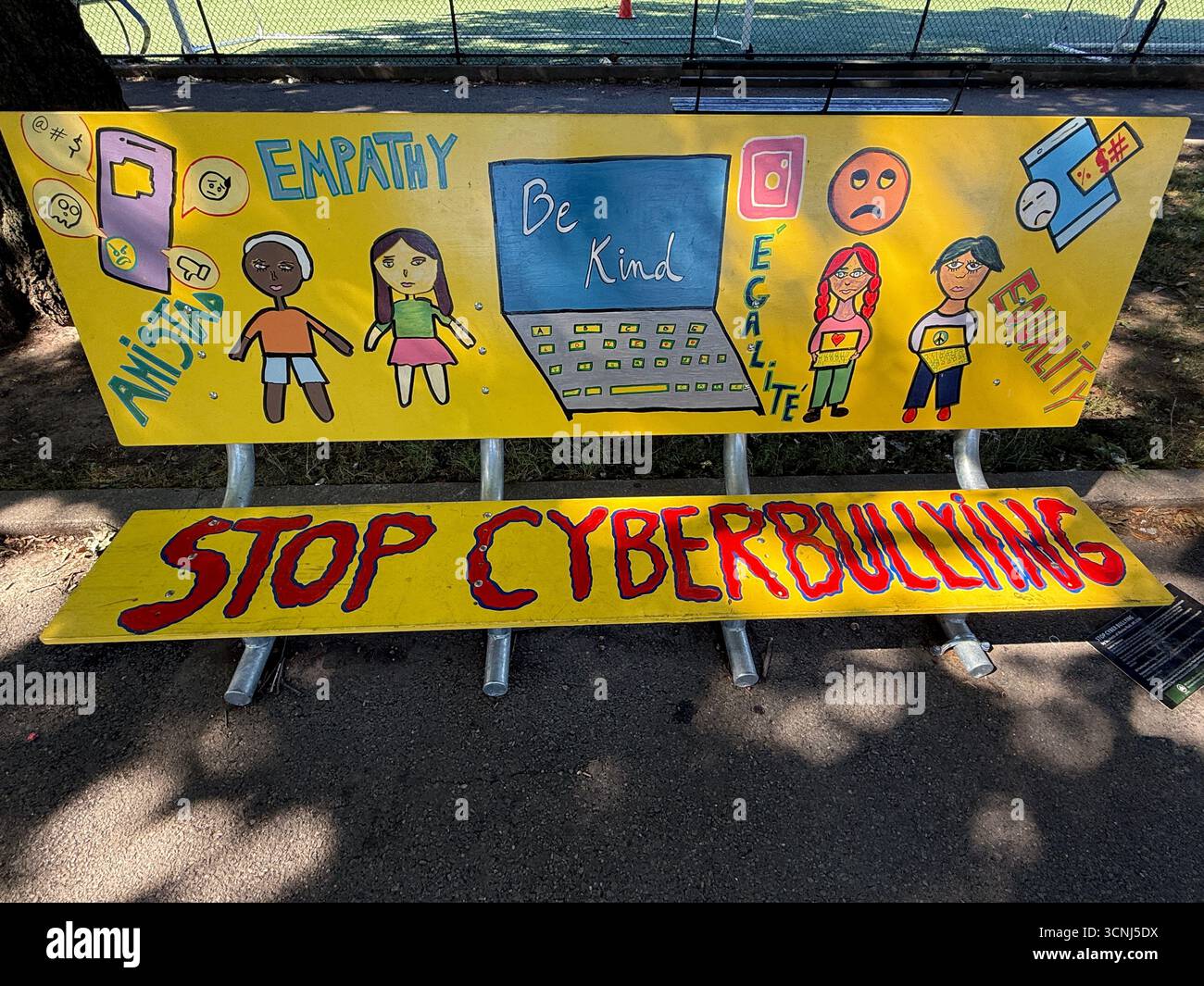 Bunt bemalte Parkbank erinnert Kinder besonders daran, andere nicht zu schikanieren, besonders Cybermobbing. Paradegelände, Brooklyn, New York. Stockfoto