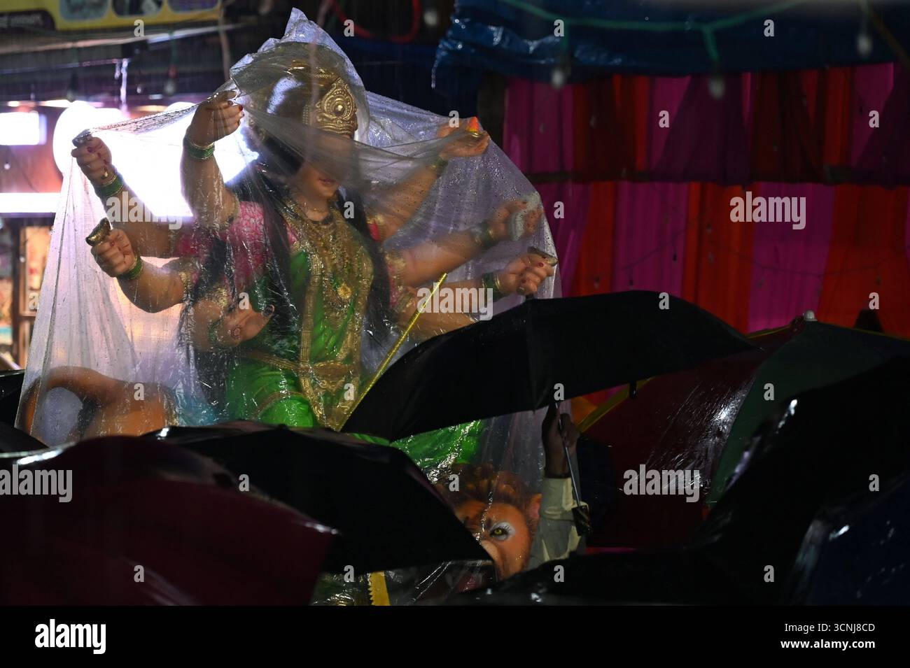 Navi MUMBAI, INDIEN – 21. SEPTEMBER: Devotees trugen das Göttin Durga-Idol mit unerschütterlicher Hingabe durch den strömenden Regen, in Richtung des Pandals, inmitten von Gesängen und Feierlichkeiten auf dem Koperkhairne Market, am 21. September 2025 in Navi Mumbai, Indien. Foto: Bachchan Kumar/Hindustan Times Vorbereitung des Durga Puja Festivals Stockfoto