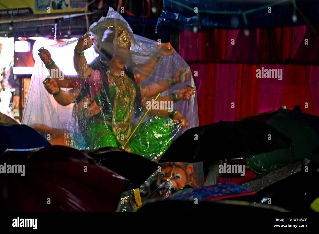Navi MUMBAI, INDIEN – 21. SEPTEMBER: Devotees trugen das Göttin Durga-Idol mit unerschütterlicher Hingabe durch den strömenden Regen, in Richtung des Pandals, inmitten von Gesängen und Feierlichkeiten auf dem Koperkhairne Market, am 21. September 2025 in Navi Mumbai, Indien. Foto: Bachchan Kumar/Hindustan Times Vorbereitung des Durga Puja Festivals Stockfoto