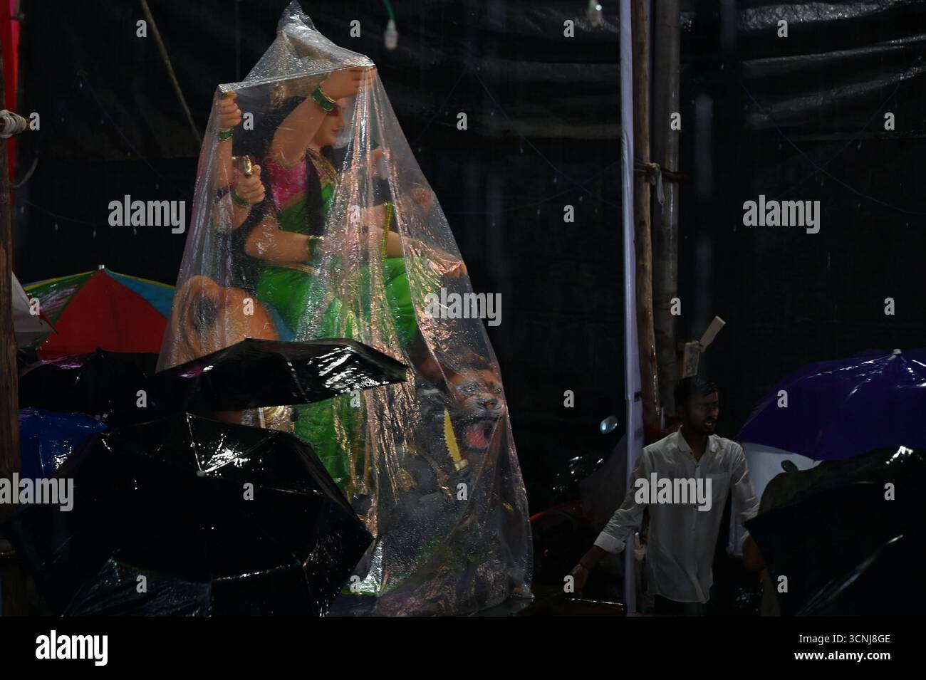 Navi MUMBAI, INDIEN – 21. SEPTEMBER: Devotees trugen das Göttin Durga-Idol mit unerschütterlicher Hingabe durch den strömenden Regen, in Richtung des Pandals, inmitten von Gesängen und Feierlichkeiten auf dem Koperkhairne Market, am 21. September 2025 in Navi Mumbai, Indien. Foto: Bachchan Kumar/Hindustan Times Vorbereitung des Durga Puja Festivals Stockfoto