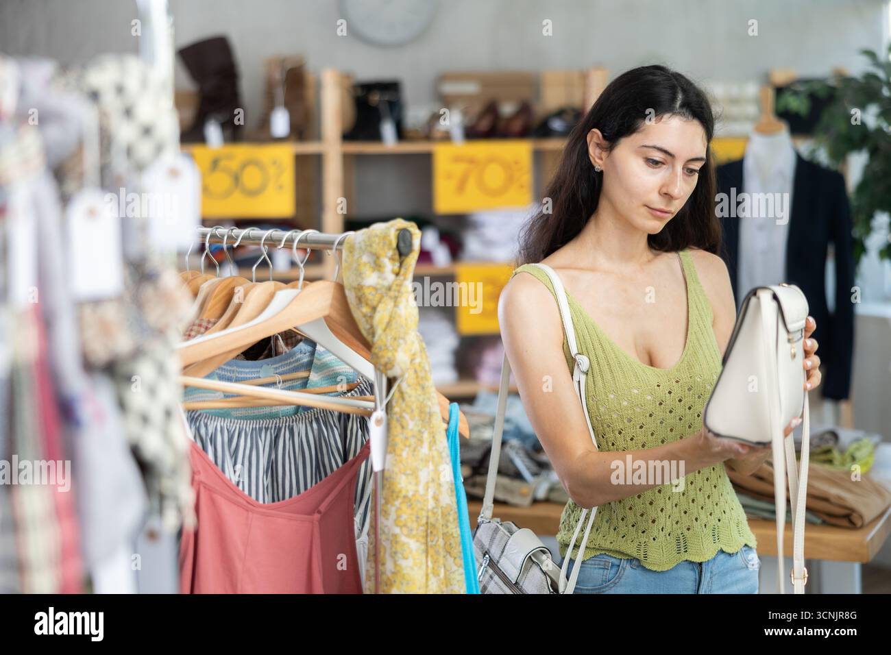 Armenische Frau, die eine modische Handtasche wählt Stockfoto
