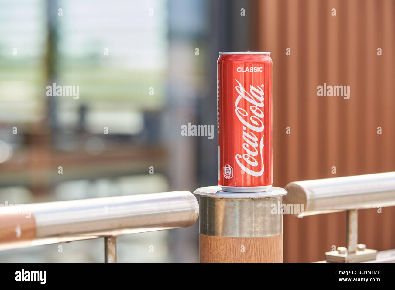 BARNAUL, SIBIRIEN, REGION ALTAI, RUSSLAND - 5. Juli 2019: Klassische Coca-Cola-Dose auf Außengeländern, die das Sommerlicht in städtischer Umgebung reflektieren. Stockfoto