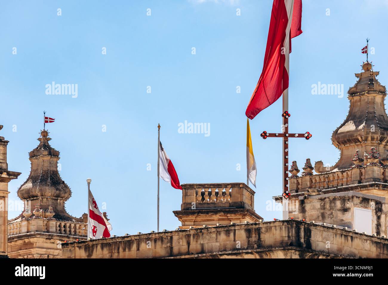 Flaggen, darunter die Flagge des Souveränen Malteserordens, die maltesische Nationalflagge, die Vatikanische Flagge und andere auf dem historischen Gebäude im Zentrum Stockfoto