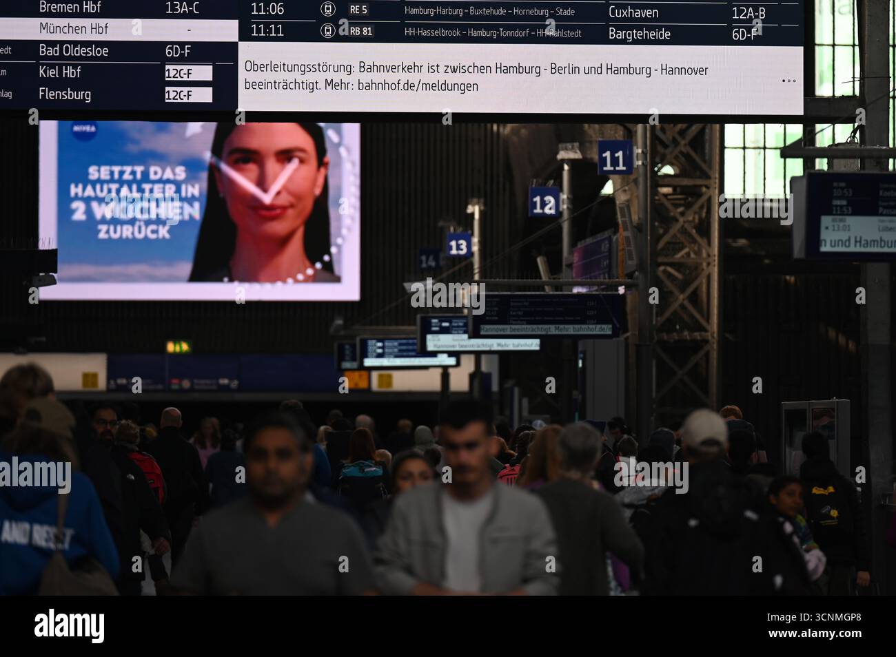 Hamburg, Deutschland. September 2025. Reisende gehen am Hamburger Hauptbahnhof zu Fuß, während eine Bahnstation der Deutschen Bahn einen Fahrleitungsfehler anzeigt. Eine gebrochene Freileitung führte heute Morgen zu starken Einschränkungen des Eisenbahnverkehrs im Norden. Quelle: David Hammersen/epa AAP/dpa/Alamy Live News Stockfoto