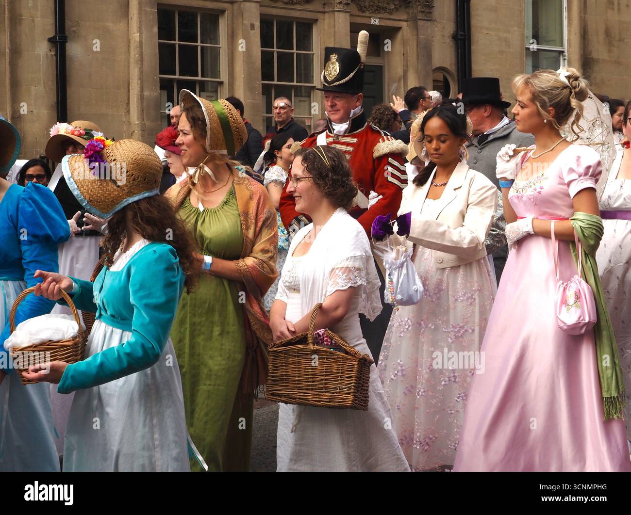 Menschen, die in Regentschaftskostümen gekleidet sind, nehmen an einer Promenade durch die Straßen von Bath bei der Jane Austen Festival Parade 2025 teil. Stockfoto