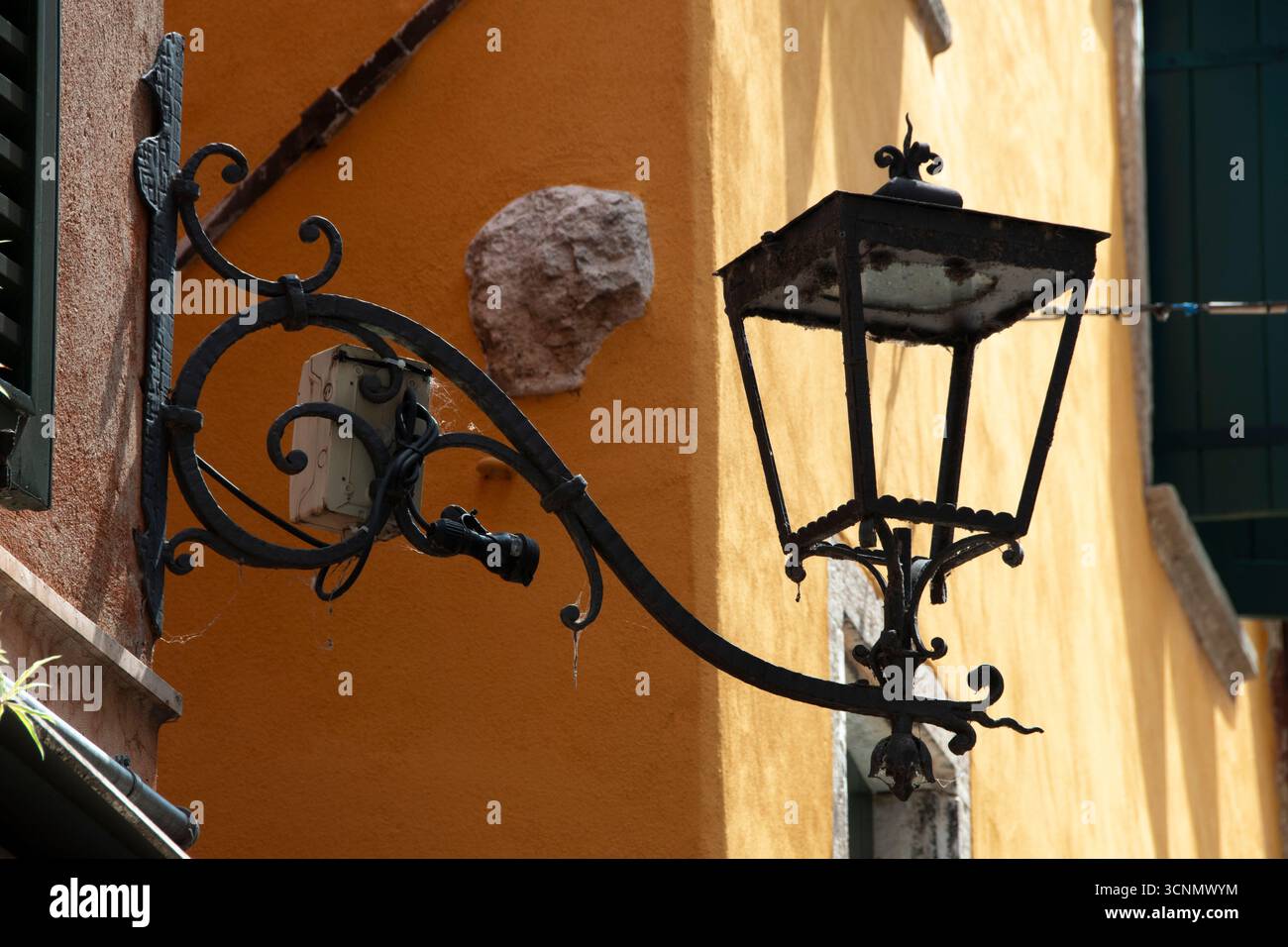 Verzierte Straßenlaterne auf gelbem Gebäude, Gardasee, Verona, Italien Stockfoto