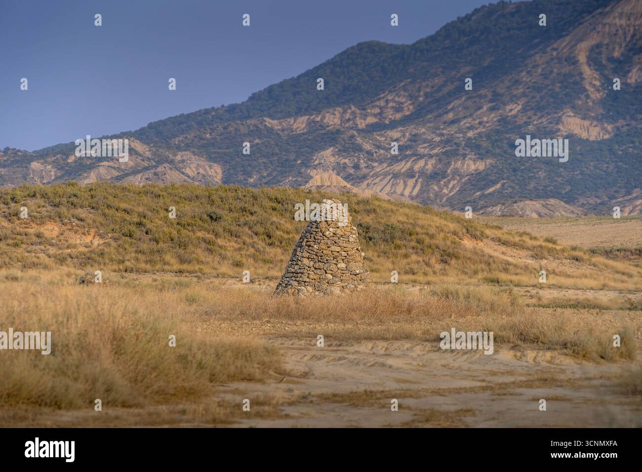 Stone Cairn Landmark In Bardenas Reales Halbwüstenlandschaft Navarra Spanien. Pyramidenförmiger Wanderpunkt, Naturpark Wildnis-Gelände Stockfoto