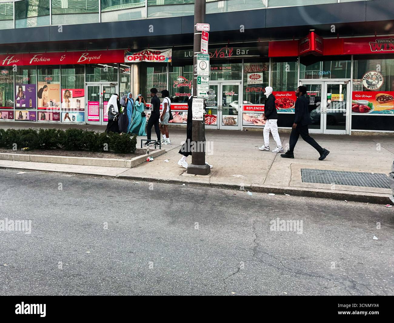 Philadelphia, Pennsylvania, USA - 29. April 2025: Fußgänger schlendern auf einem belebten Bürgersteig vorbei an Beauty- und Modegeschäften in Philadelphia. Stockfoto