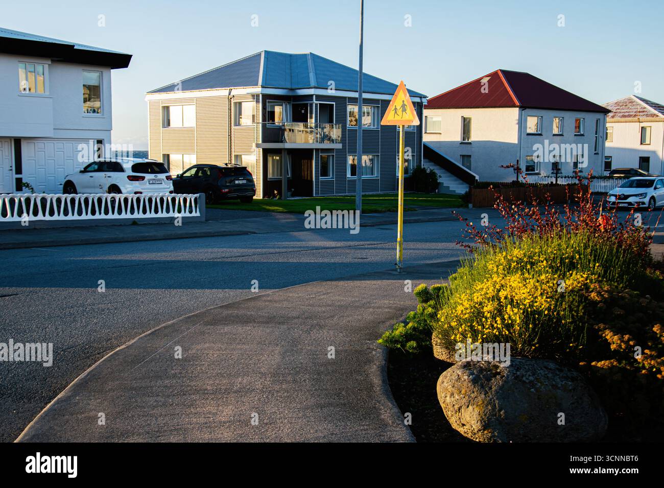 Akranes, Island - 17. September 2025: Gemütliches Küstenviertel in Akranes, Island, mit modernen Häusern, geparkten Autos, einem Fußgängerschild und Stockfoto