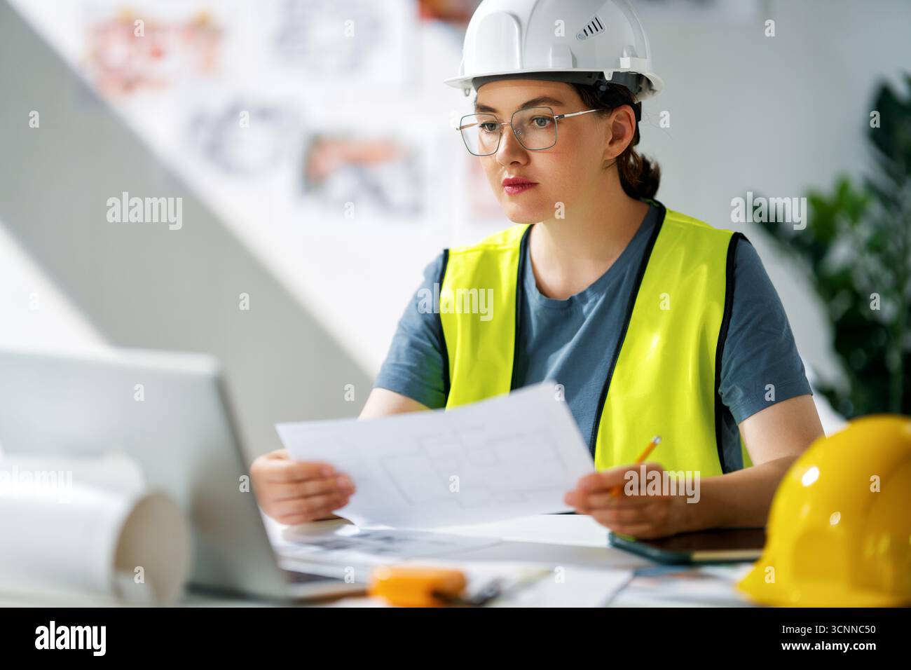 Die Architektin arbeitet an Plänen auf der Baustelle. Stockfoto