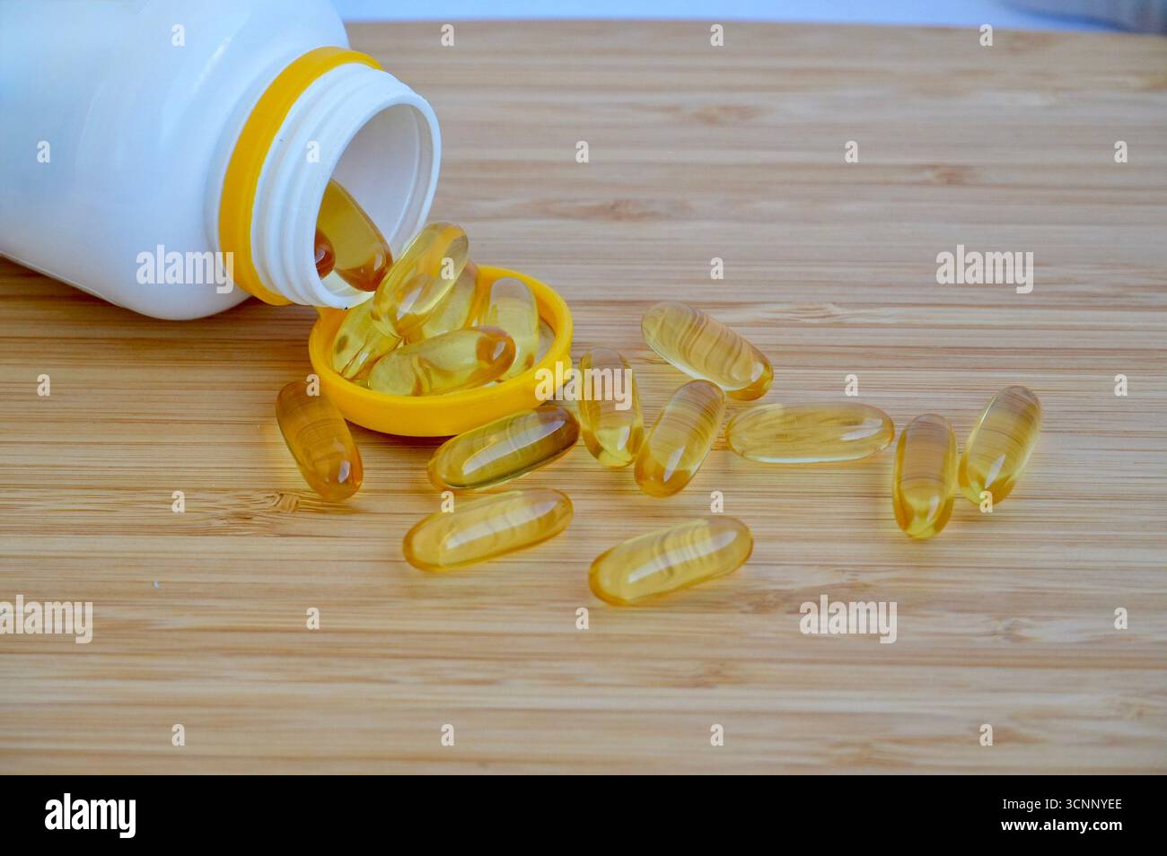 Fischöl Kapseln auf einem Holztisch mit einer Flasche Öl. Stockfoto