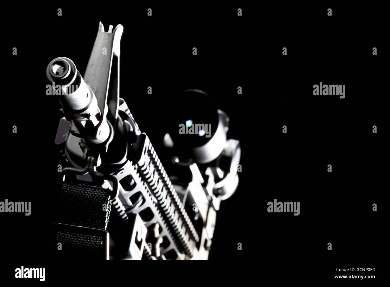 Ein AR-15-Gewehr wird in scharfen Details aufgenommen und in einem Studio vor tiefschwarzem Hintergrund fotografiert, dessen schlanke Linien und Metallic-Oberfläche hervorgehoben sind Stockfoto