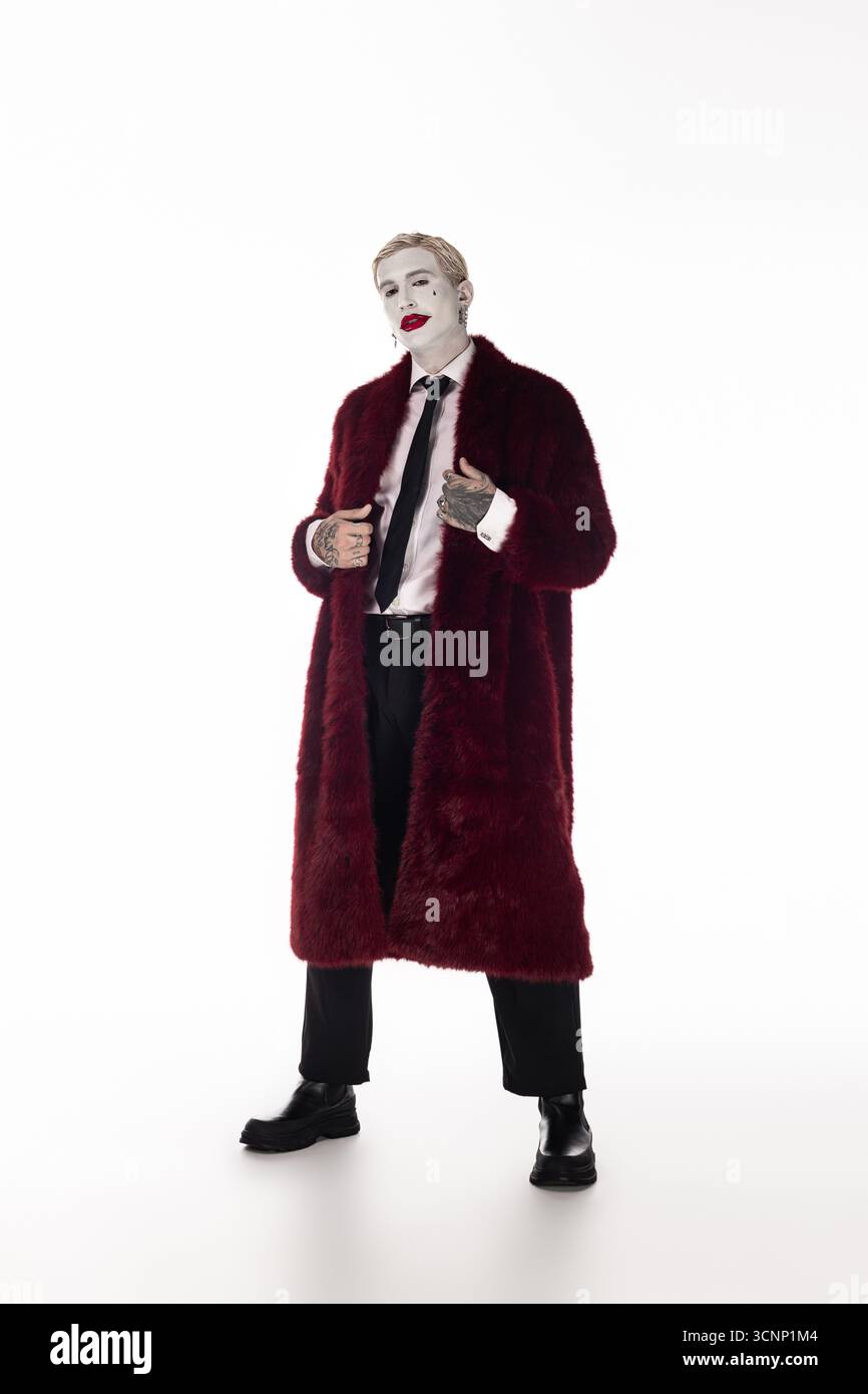 Ein junger Mann zeigt seinen Halloween-Geist in einem epischen Joker-Kostüm, das Stil und Spaß vereint. Stockfoto