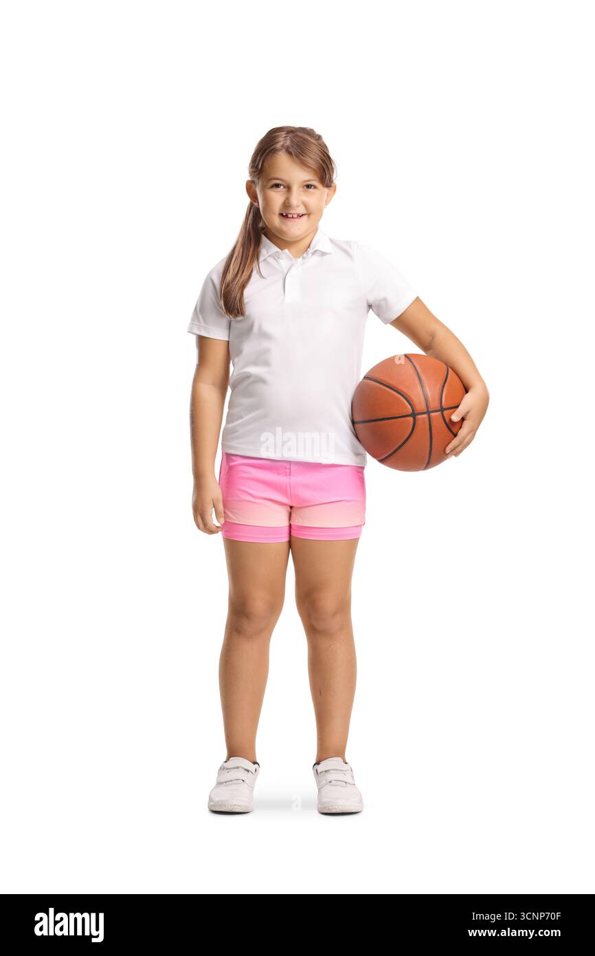 Kleines Mädchen lächelt und hält einen Basketball isoliert auf weißem Hintergrund Stockfoto