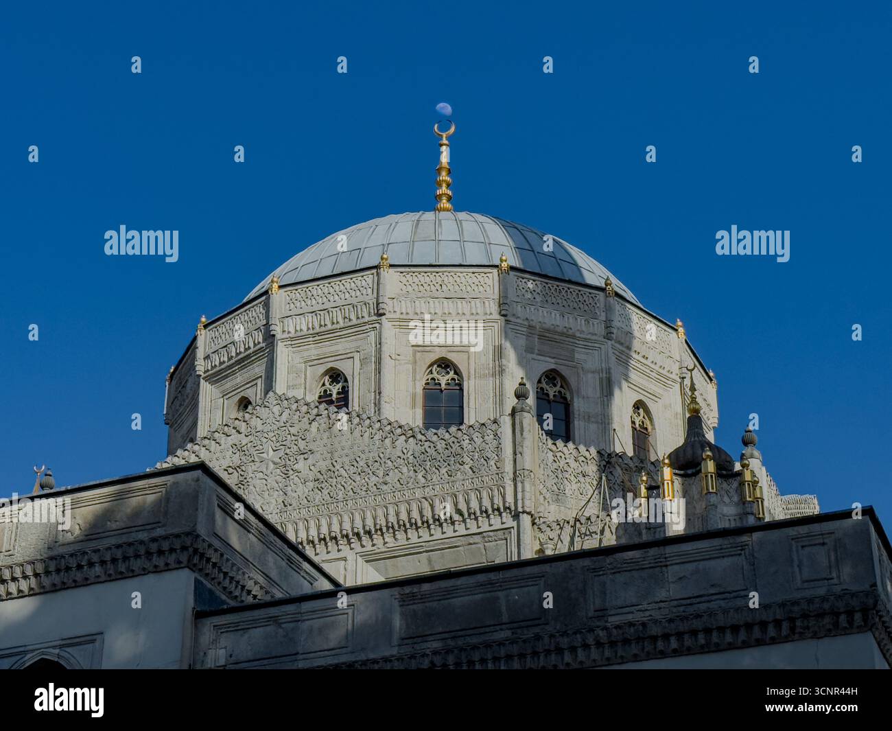 Reich verzierte osmanische Moschee Kuppel unter klarem blauem Himmel Stockfoto