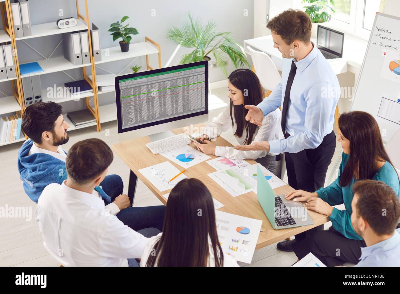 Business-Team teilt sich im Büro einen Laptop, sieht sich die Präsentation der Buchhaltung von Startup-Unternehmen an, sieht das Finanzprojekt an Stockfoto