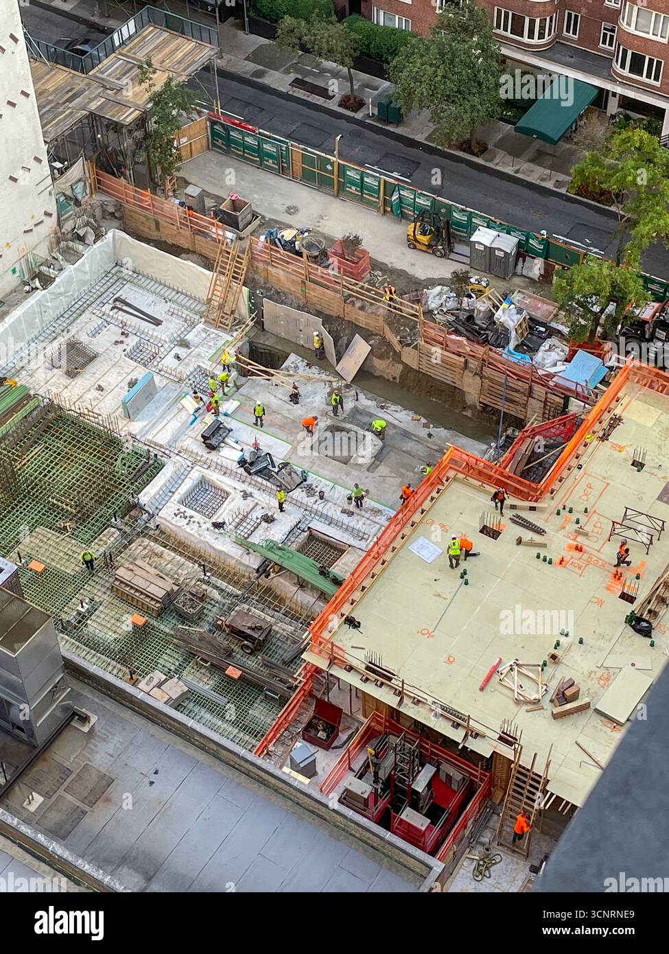 Bauarbeiter legen den Grundstein für ein Hochhaus im Murray Hill Historic District, 2025, New York City, USA - Smartphone-aufgenommenes Stockfoto