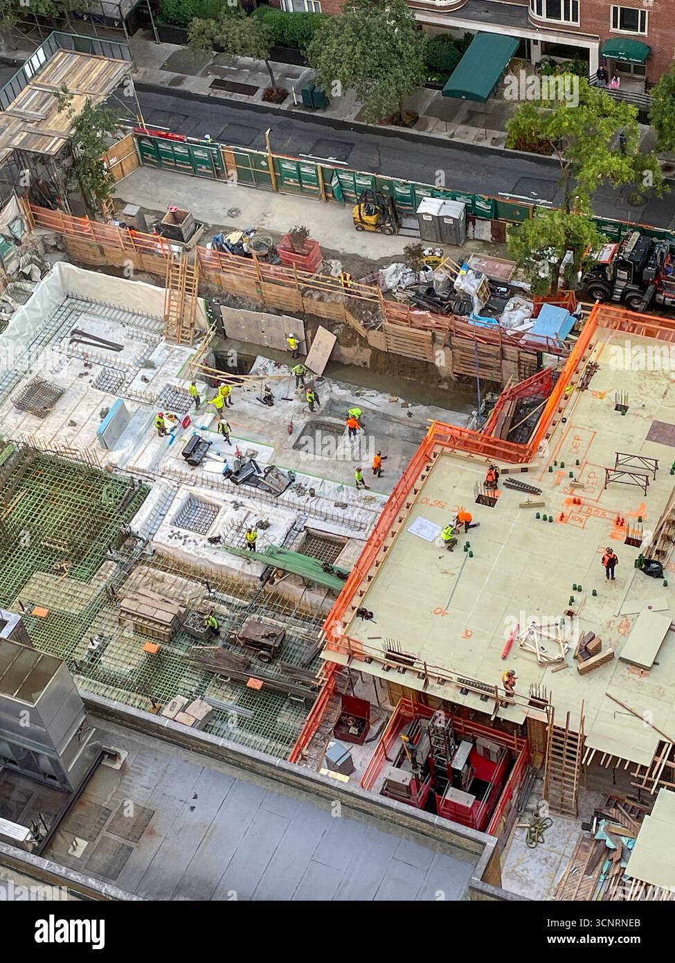 Bauarbeiter legen den Grundstein für ein Hochhaus im Murray Hill Historic District, 2025, New York City, USA - Smartphone-aufgenommenes Stockfoto