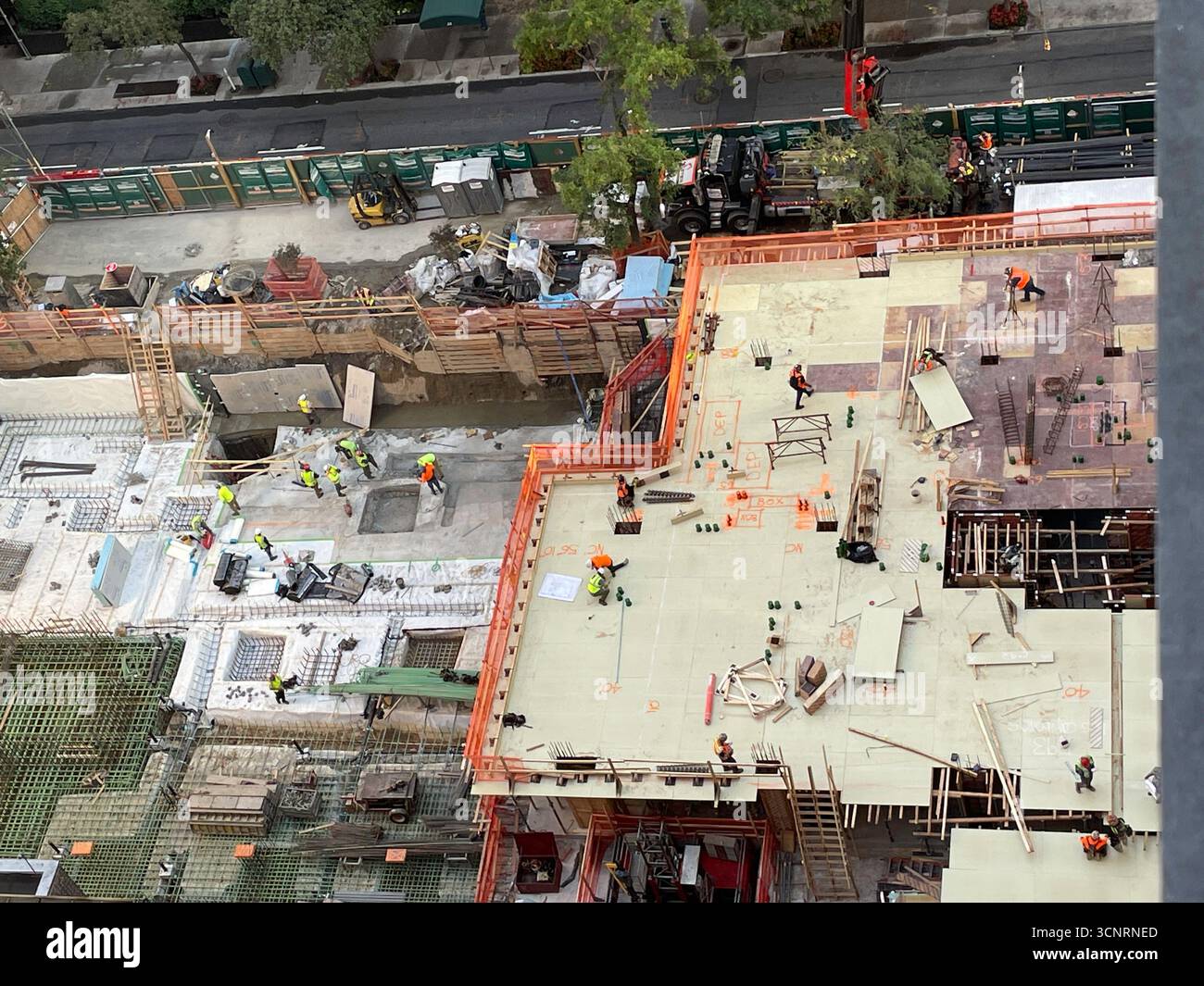 Bauarbeiter legen den Grundstein für ein Hochhaus im Murray Hill Historic District, 2025, New York City, USA - Smartphone-aufgenommenes Stockfoto