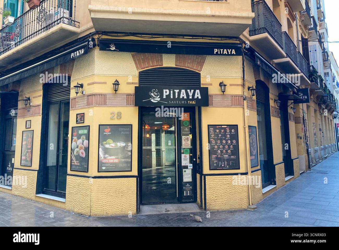 MALAGA, SPANIEN - 10. JULI 2025: Morgenspaziergang durch die ruhigen Straßen von Malaga, Spanien, mit sanftem Sonnenlicht und ruhiger Stadtatmosphäre. - Smartphone-aufgenommenes Stockfoto