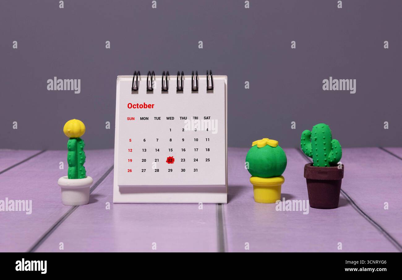 Holzkalender mit Datum 22. Oktober. Monatskalender für Planung und Management-Konzept mit Wecker auf hölzernem Hintergrund Stockfoto