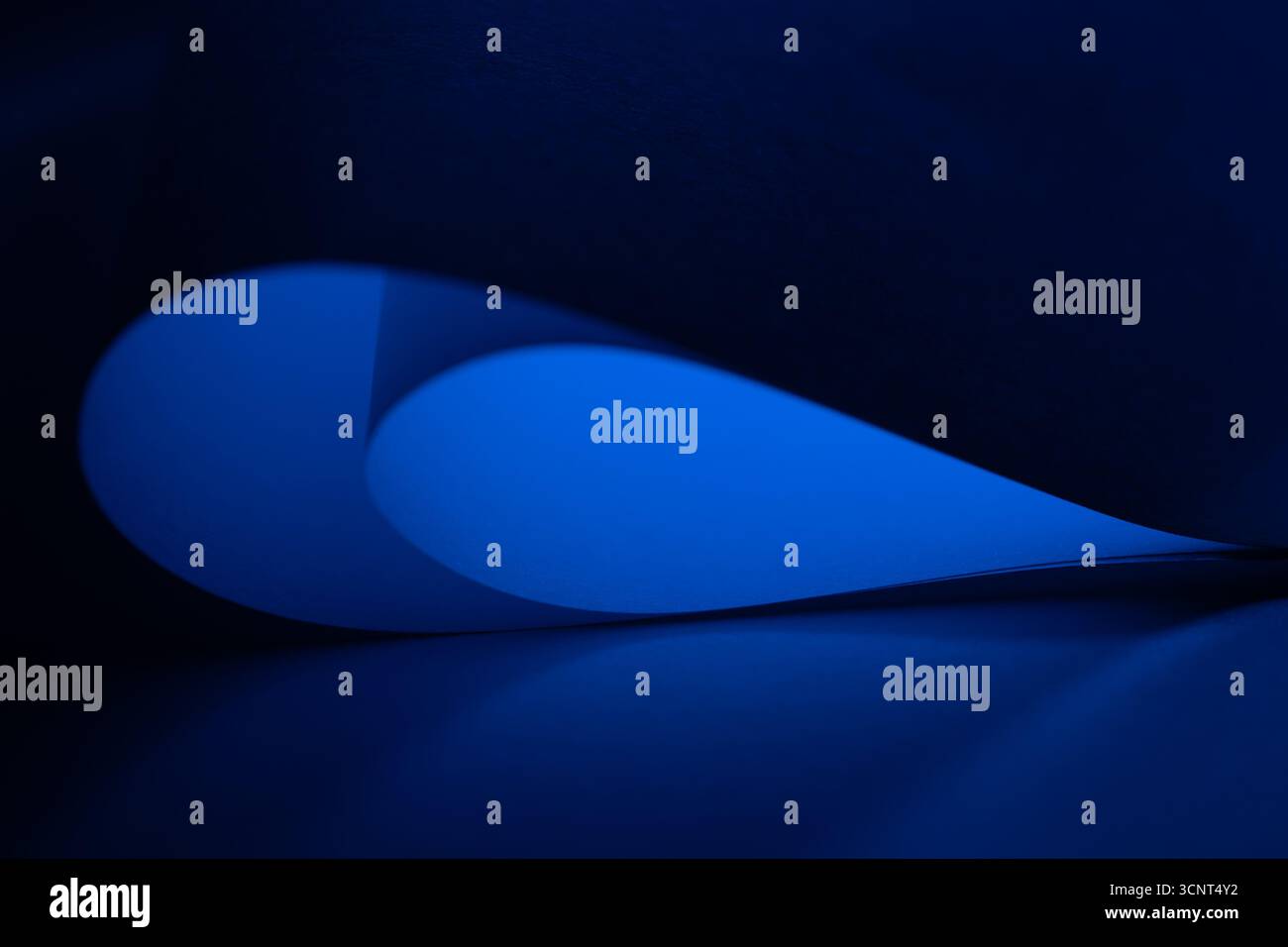 Geschwungene Formen in leuchtendem Blau und Schwarz verschmelzen harmonisch und schaffen eine ansprechende abstrakte Komposition, die den Betrachter einlädt, Text zu erkunden Stockfoto