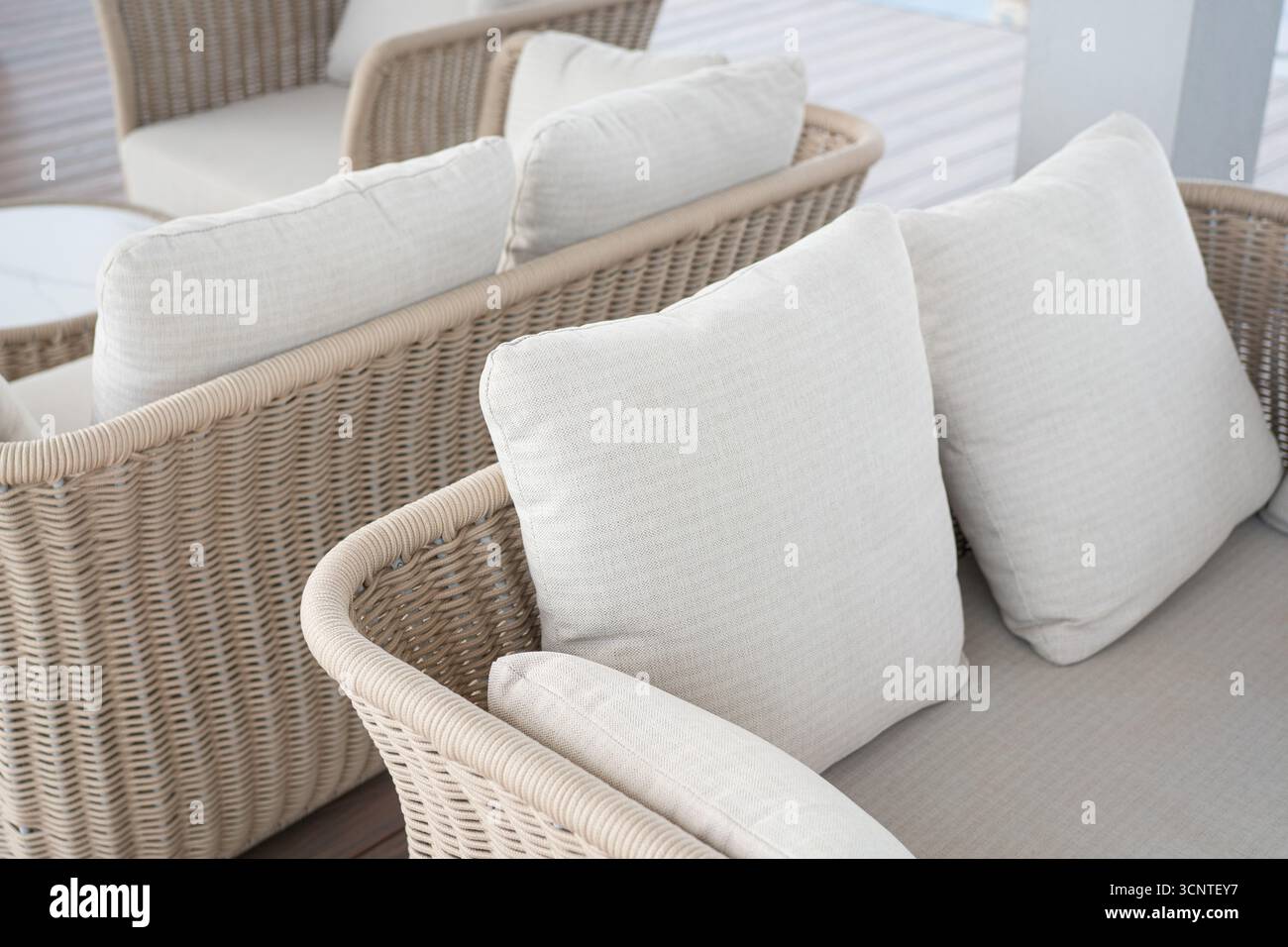 Rattan-Sofa im Freien auf einer Holzterrasse. Stockfoto