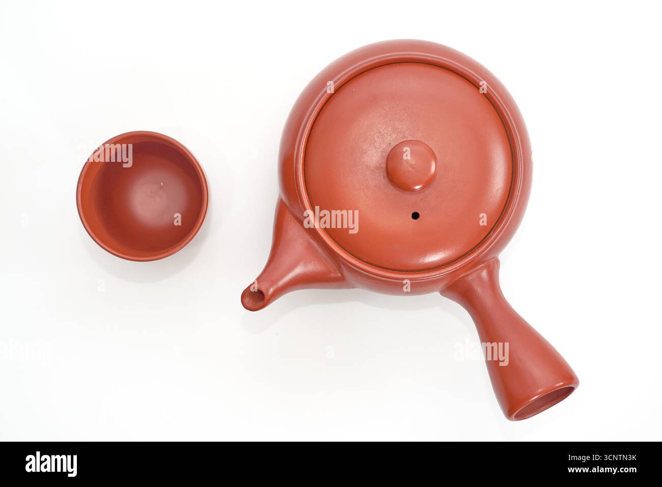 Eine Top-Down-Studioaufnahme eines traditionellen japanischen Teesets mit brauner Kyusu-Keramikkanne mit markantem Seitengriff und passendem Griff Stockfoto