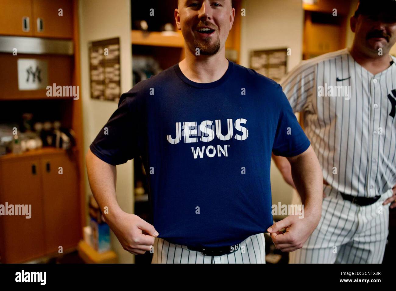 Der New York Yankees-Spieler in der Umkleidekabine zeigt ein blaues Hemd mit dem Aufdruck „Jesus Won“ auf der Vorderseite. Yankee Stadium, New York, USA. September 2025. Stockfoto