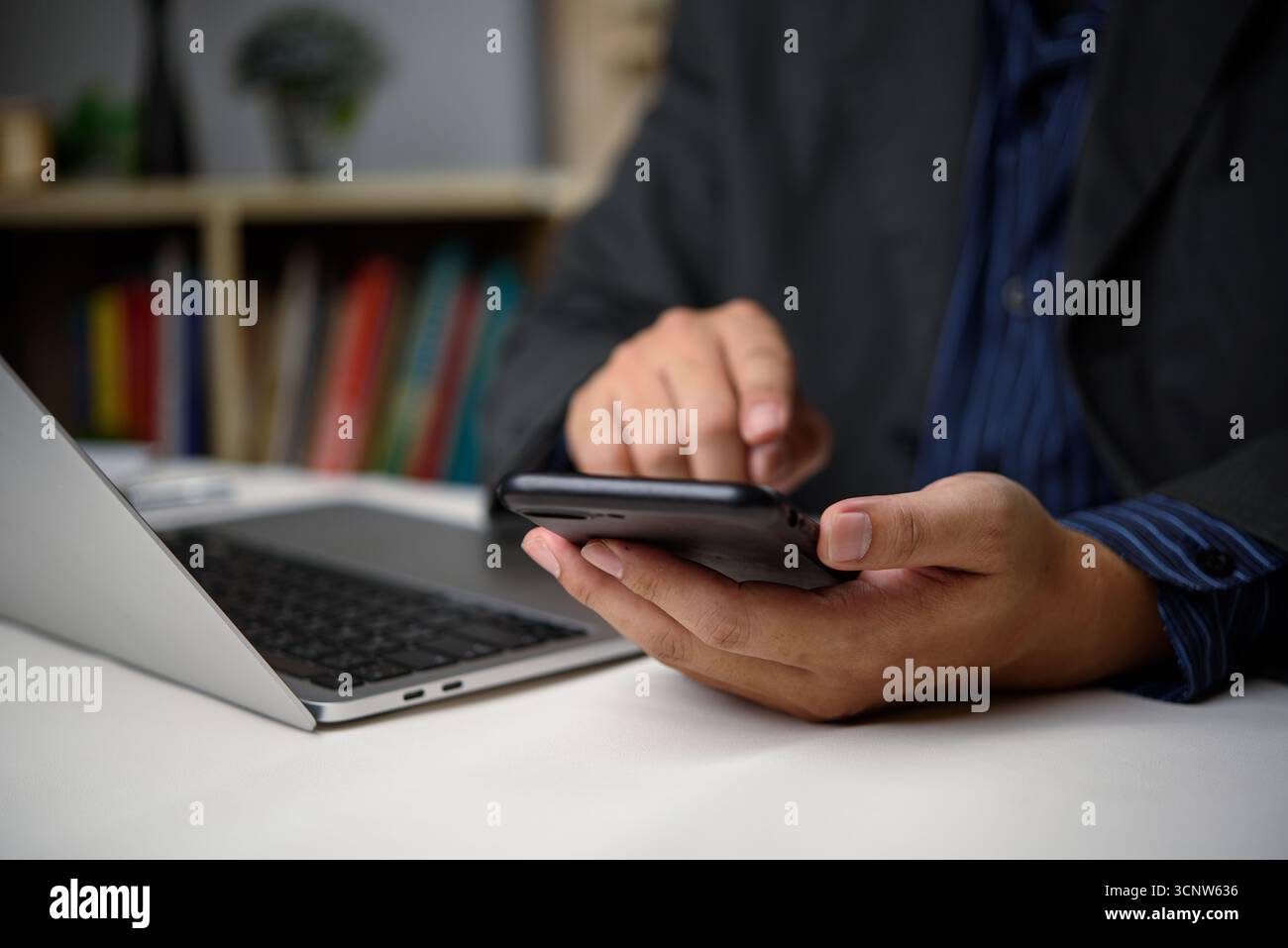 Smartphone mit Handgriff, das online auf einem Laptop arbeitet, modernes digitales Social-Media-Netzwerk und Technologie für Business-Marketing-Finanzierung. Stockfoto