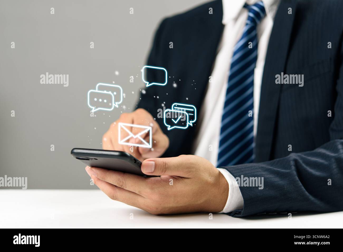 Geschäftsmann, der ein Smartphone mit digitalen Chat- und E-Mail-Symbolen, Kommunikation Online-Nachrichten, soziale Medien, mobiles Marketing und moderne Kunden hält Stockfoto