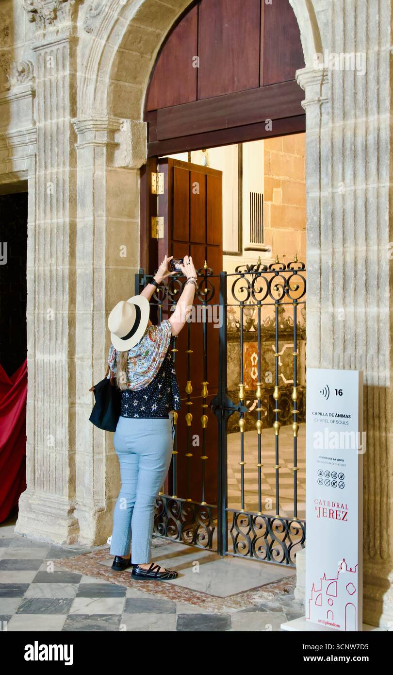 Frau, die ein Handy-Foto von einer geschlossenen Kapelle in der Kathedrale des Heiligen Erlösers Encarnación Jerez de la Frontera Spanien macht Stockfoto