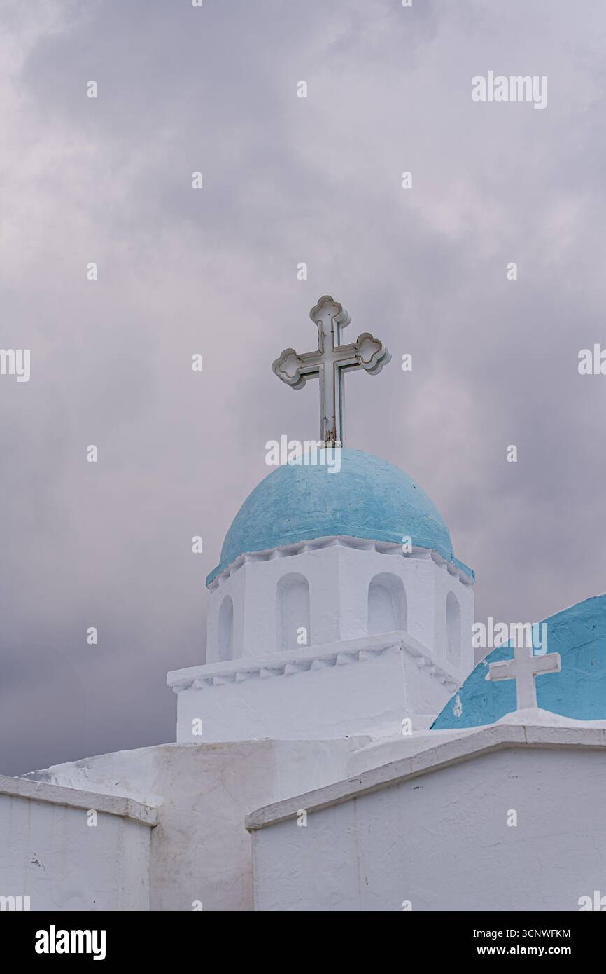 Unter einem dramatischen bewölkten Himmel steht eine markante Kirche mit blauer Kuppel und einem markanten Kreuz, die die ruhige und zeitlose Architektur widerspiegelt Stockfoto