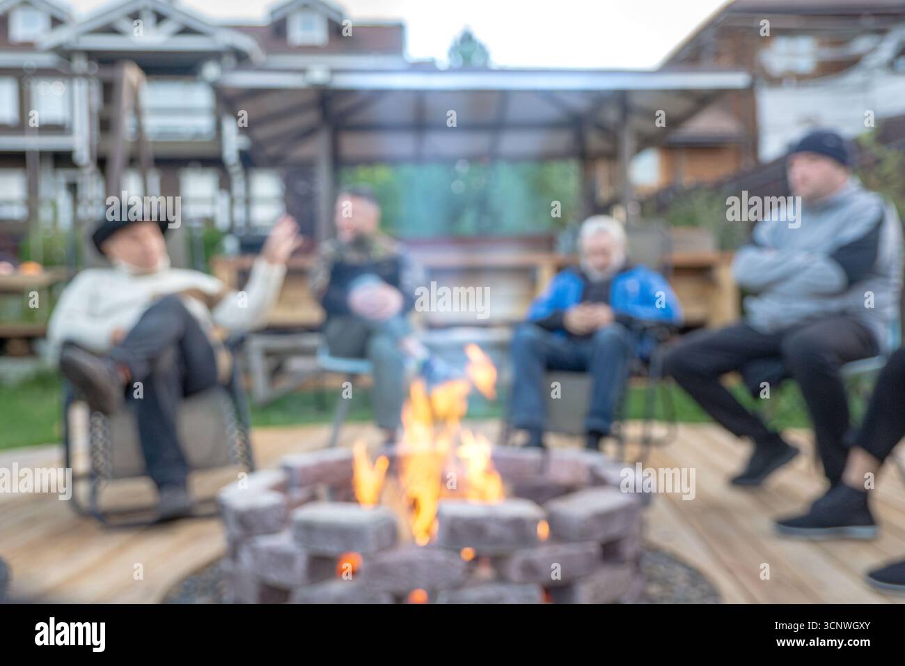 Sich um ein Feuer zu sammeln, fördert emotionale Verbindungen, reduziert Stress und stärkt Beziehungen mit Unschärfe Stockfoto