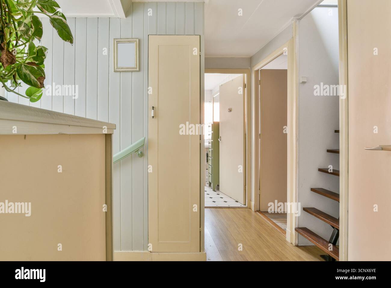 Heller und einladender Innenkorridor mit Treppe, Türen und hellem Farbschema. Tageslicht verstärkt die ruhige Atmosphäre des Spa Stockfoto