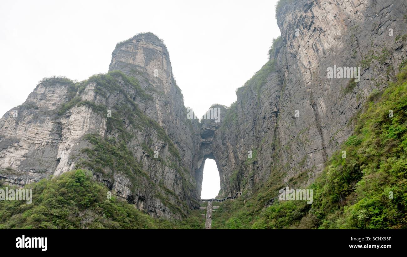 Vorderansicht der Tianmen-Höhle, ein natürlicher Felsbogen, der auch Himmelstor genannt wird und sich in Tianmen Dongkai auf 1.300 Metern auf dem Berg des Himmlischen Friedens in Zhangjiaj befindet Stockfoto