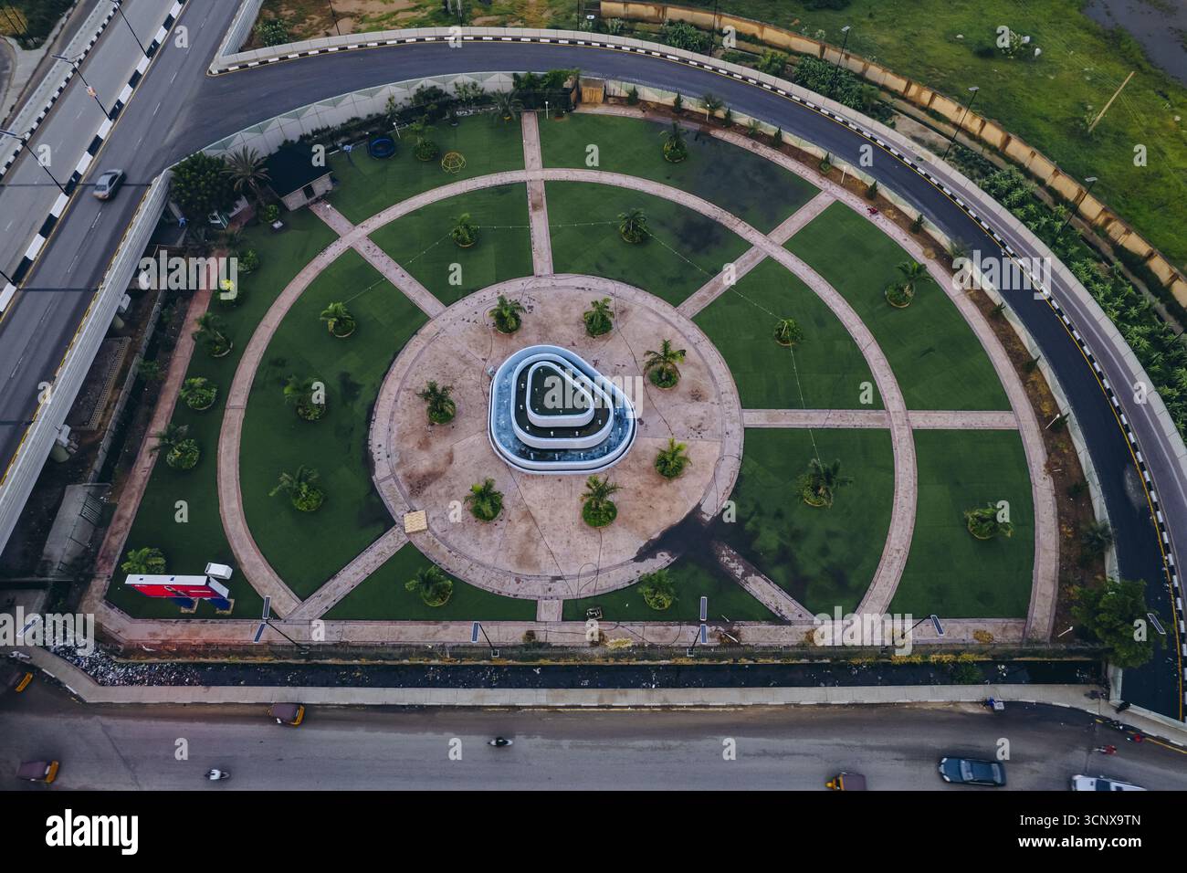Blick aus der Vogelperspektive auf den Kreisverkehr der Dangi Bridge mit üppigem grünem Gras, kreisförmigen Mustern und einem zentralen Brunnen, Kano, Kano, Nigeria. Stockfoto