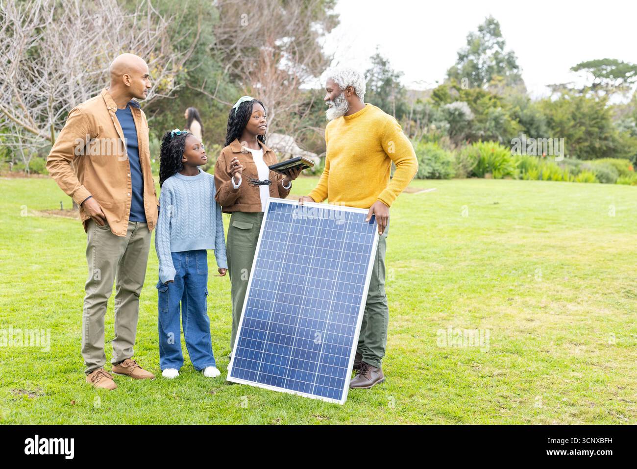 Afroamerikanische Familienberatung mit Solarspezialist im Freiland, der Panel Tablet und Stift hält Stockfoto
