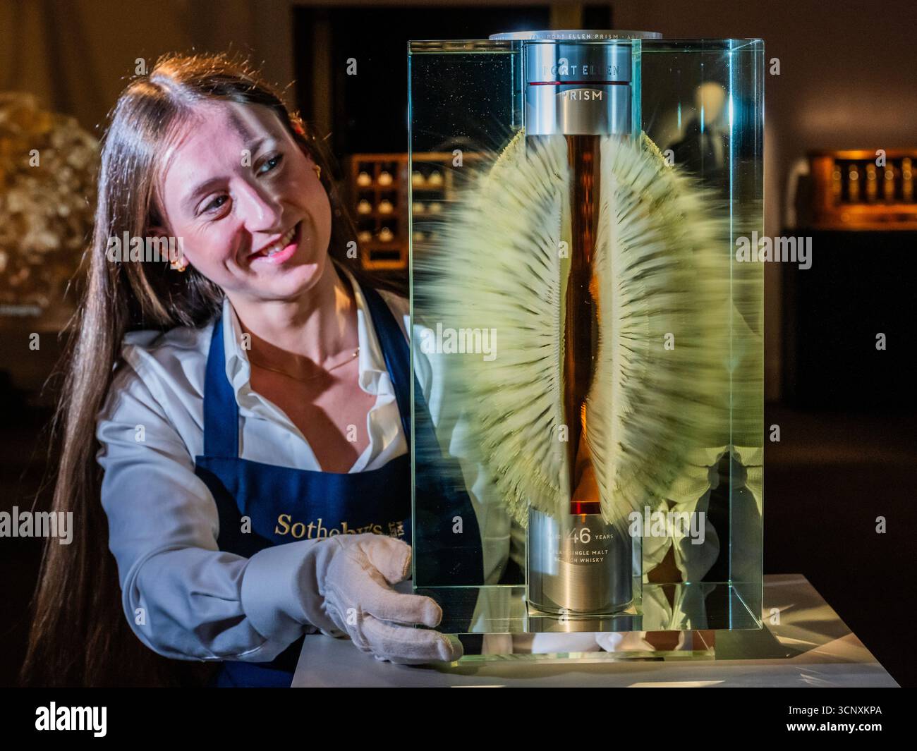 London, Großbritannien. September 2025. Der älteste Port Ellen Single Malt Scotch Whisky, der von der Destillerie veröffentlicht wurde. Präsentiert in einer 1,5-Liter-Kristalldekanter, umhüllt von einer Glasskulptur des Künstlers Wilfried Grootens, Est £ 150.000-300.000 - Eine Vorschau auf die dritte Ausgabe von The Distillers' One of One Auktion von ultra-seltenem Whisky in Sothebys, London. Mit 39 einmaligen Losen, die von Scotch Whisky Destilleries gespendet wurden. Die Erlöse kommen der Destillers' Charity und dem Youth Action Fund zugute, wobei seit der ersten Auktion im Jahr 2021 4,3 Mio. £ gesammelt wurden. Die Auktion findet am 10. Oktober 2025 im Hopetoun House in der Nähe von Edinburgh statt. Credi Stockfoto