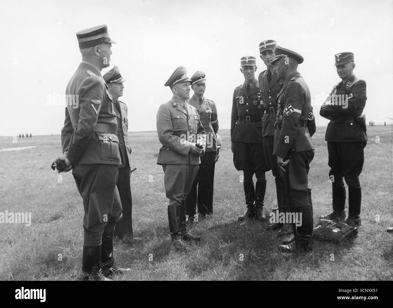 Der stellvertretende Gauleiter Ferdinand Grossherr (Mitte, Handschuhe in der Hand) und Obergruppenführer NSFK Ewald Oppermann (erster von links), umgeben von weiteren Offizieren, erhalten einen Bericht des Hitlerjugend-Bezirksinspektors Burkhardt. 1944 Stockfoto
