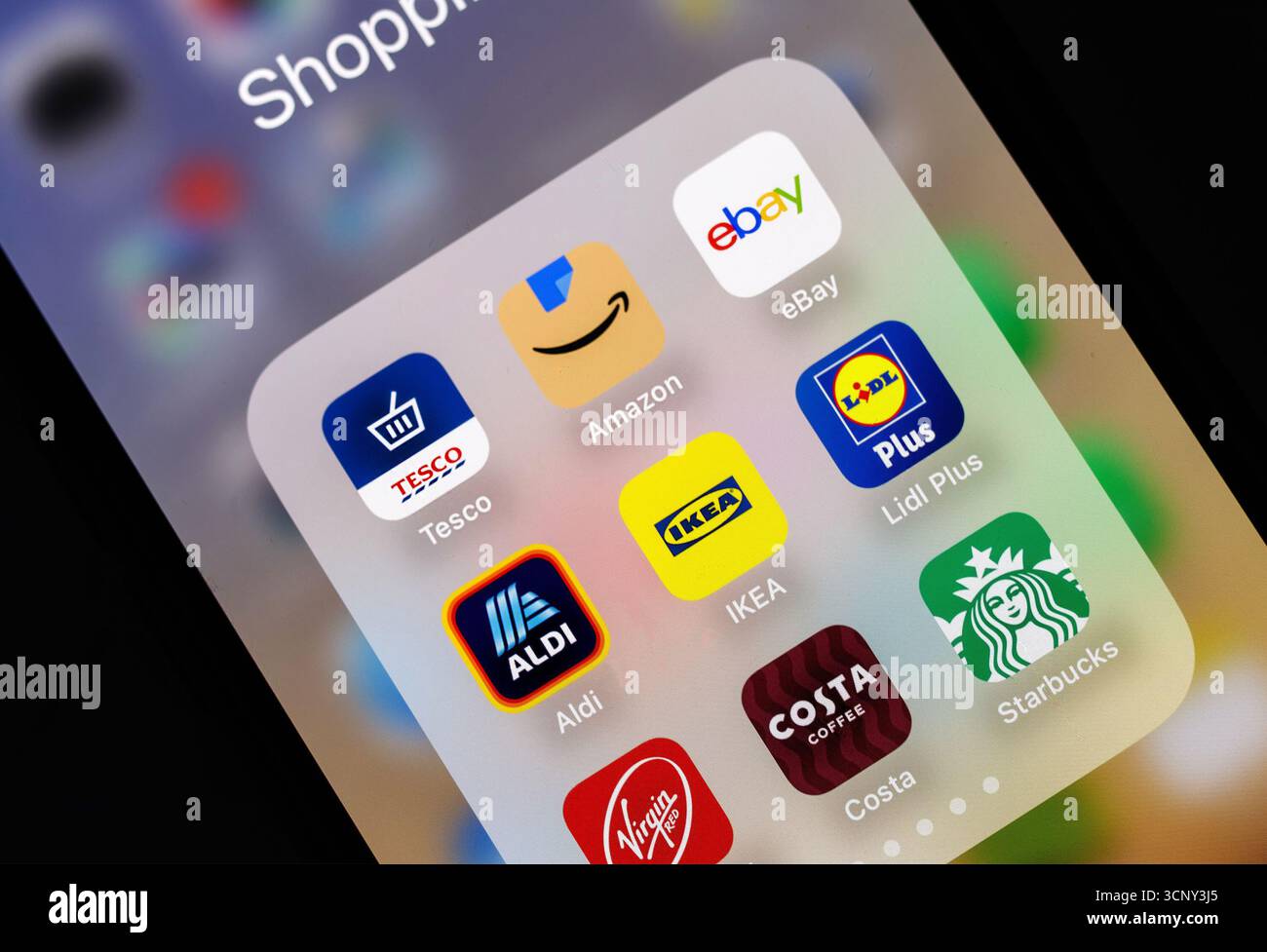 iphone Smartphone-Bildschirm mit Symbolen für Shopping-Apps wie Amazon, eBay, Tesco, IKEA und Starbucks, die Vorteile des Online-Einzelhandels hervorheben Stockfoto