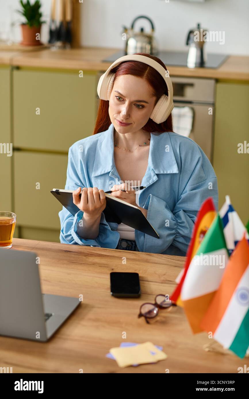 Eine Frau mit rotem Haar hilft Schülern, online Sprachen zu lernen, während sie an ihrem Laptop sitzt. Stockfoto