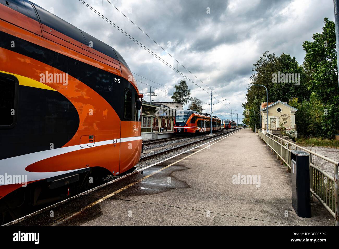 Moderne Elron-Personenzüge am Bahnhof Tartu in Estland, mit orangefarbener Lackierung auf Gleisen unter bewölktem Himmel an diesem wichtigen Verkehrsknotenpunkt der Ostsee. Stockfoto