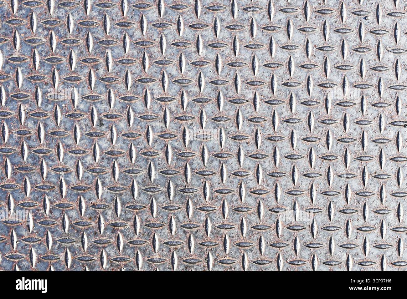 Metallstahlplatte mit Rautenmuster. Industrieller texturierter Hintergrund. Silberglänzende Oberfläche mit erhöhten Linien. Details des Baumaterials. Stockfoto