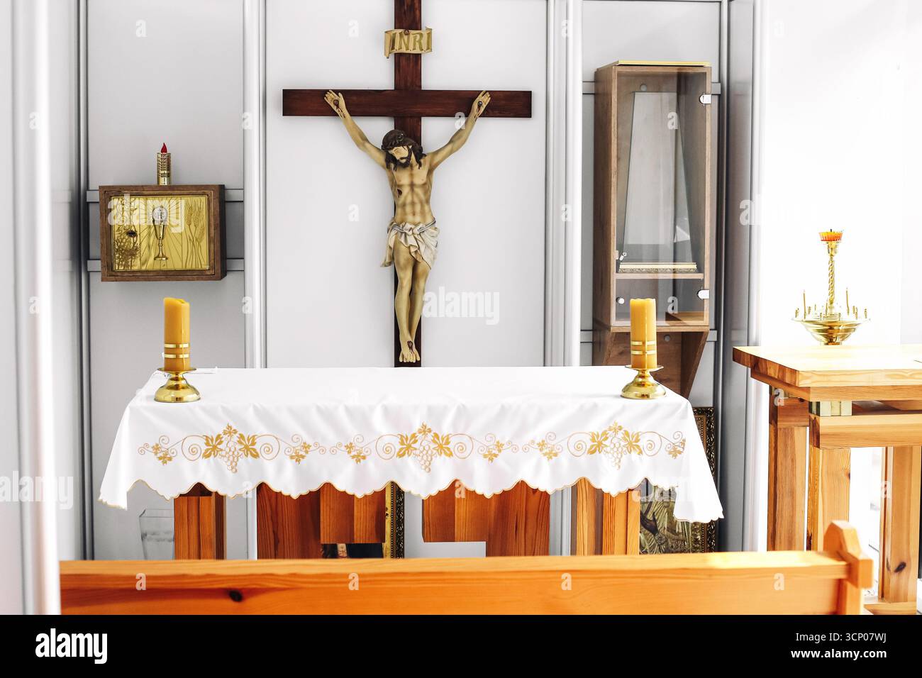 Kirchenaltar mit Kruzifix. Christliches Religionssymbol. Heiliger Ort mit goldenem Kreuz und liturgischer Dekoration. Katholischer glaube und Spiritualität. Stockfoto